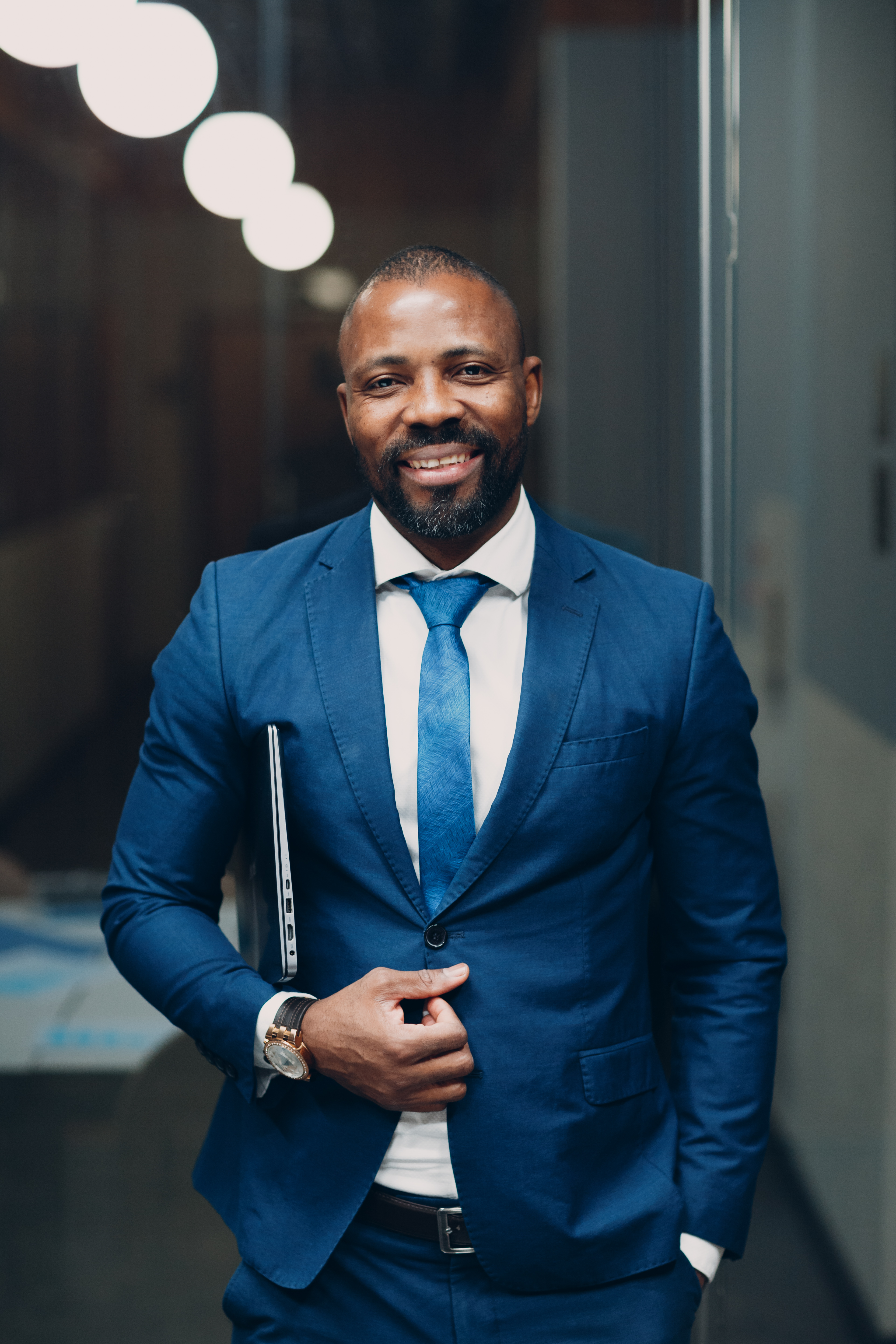 Portrait smiling african-american businessman in blue formal suit in office.